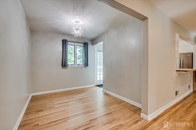 74 Hazelwood Ave, Metuchen, NJ 08840 - unfurnished room with light wood-style flooring and a chandelier