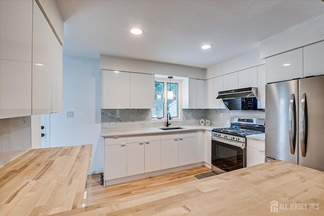 74 Hazelwood Ave, Metuchen, NJ 08840 - kitchen with stainless steel appliances, modern cabinets, backsplash, ventilation hood, and white cabinetry