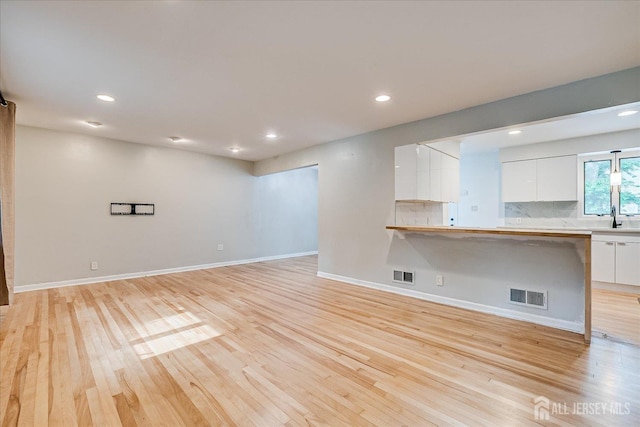 74 Hazelwood Ave, Metuchen, NJ 08840 - unfurnished living room with light wood-style flooring and recessed lighting