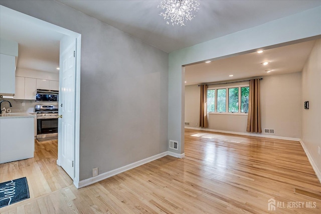 74 Hazelwood Ave, Metuchen, NJ 08840 - empty room with light wood-style flooring, a chandelier, and recessed lighting