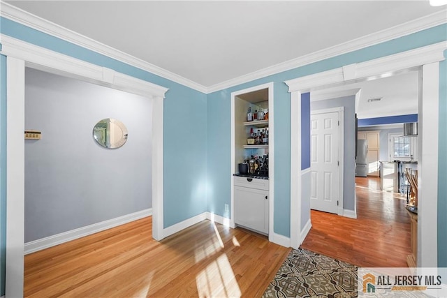 interior space with crown molding, built in shelves, and wood-type flooring