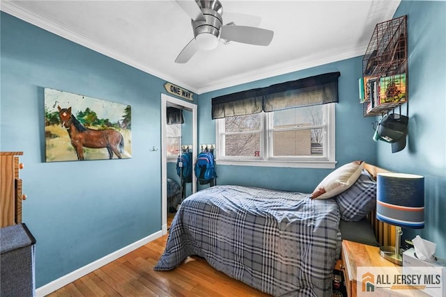 bedroom featuring ceiling fan, wood-type flooring, and ornamental molding