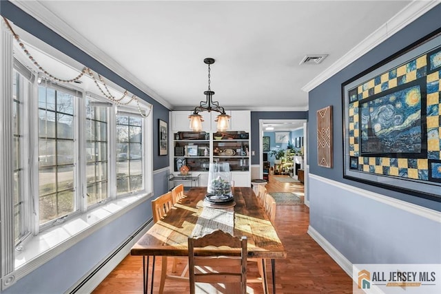 dining area featuring a notable chandelier, wood-type flooring, ornamental molding, and baseboard heating