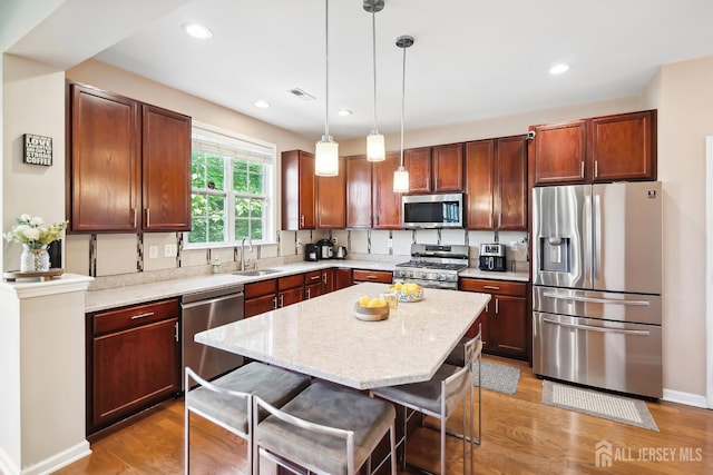 3 Lily Ln, Piscataway, NJ 08854 - kitchen with appliances with stainless steel finishes, a sink, light wood-style floors, a breakfast bar area, and pendant lighting