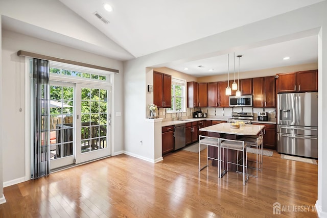 3 Lily Ln, Piscataway, NJ 08854 - kitchen featuring stainless steel appliances, light wood-style flooring, a kitchen bar, lofted ceiling, and decorative light fixtures