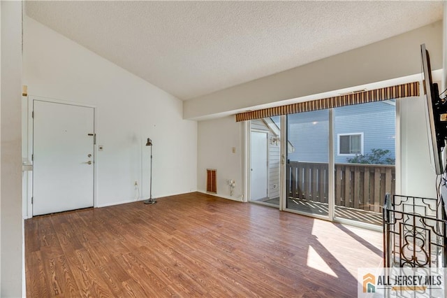 2302 Aspen Dr Unit 2302, Plainsboro, NJ 08536 - empty room featuring wood finished floors, a textured ceiling, and vaulted ceiling