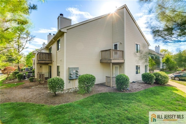2302 Aspen Dr Unit 2302, Plainsboro, NJ 08536 - view of side of home featuring a balcony, a chimney, and a lawn