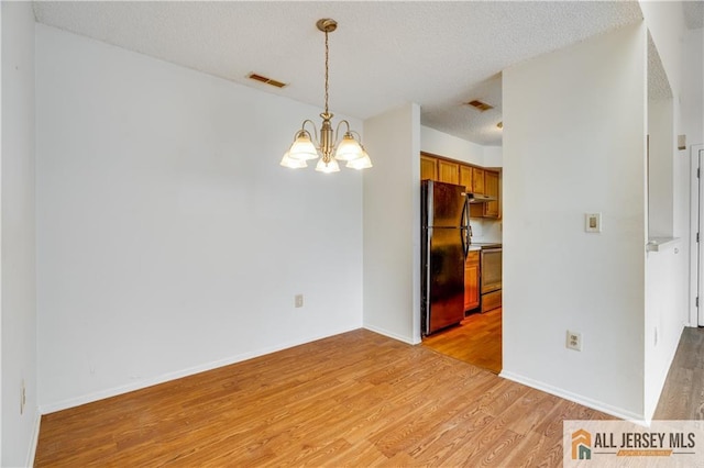 2302 Aspen Dr Unit 2302, Plainsboro, NJ 08536 - unfurnished dining area featuring light wood-style flooring, a chandelier, a textured ceiling, and baseboards
