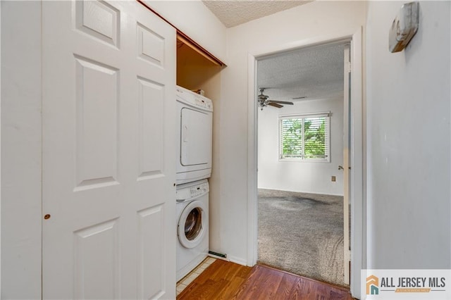2302 Aspen Dr Unit 2302, Plainsboro, NJ 08536 - washroom featuring stacked washing machine and dryer, a textured ceiling, ceiling fan, and dark wood-style flooring