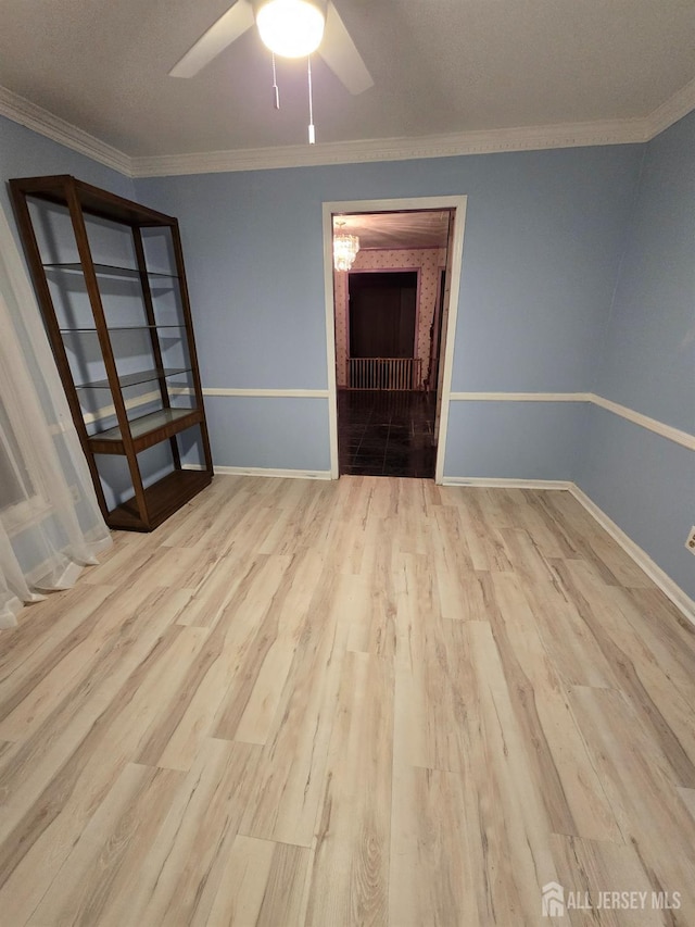 empty room featuring ceiling fan, light hardwood / wood-style flooring, and ornamental molding