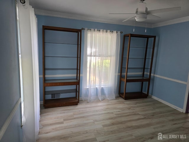 empty room featuring ceiling fan, crown molding, and light hardwood / wood-style floors