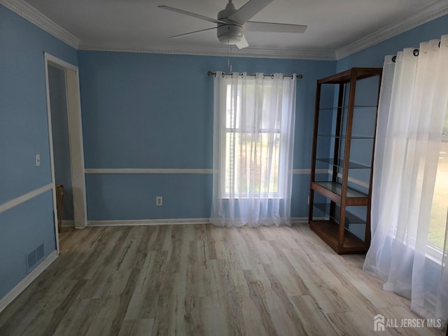 empty room with ceiling fan, hardwood / wood-style flooring, and ornamental molding