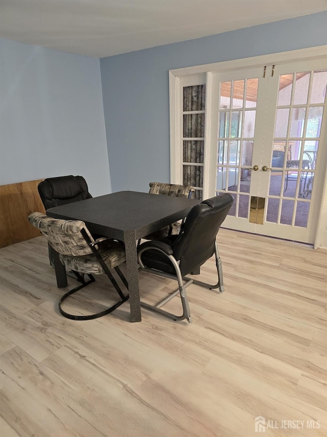 dining room featuring french doors and light hardwood / wood-style floors