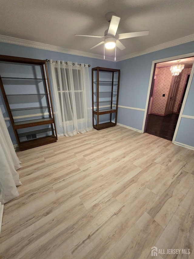 unfurnished bedroom featuring ceiling fan with notable chandelier, crown molding, and light hardwood / wood-style floors