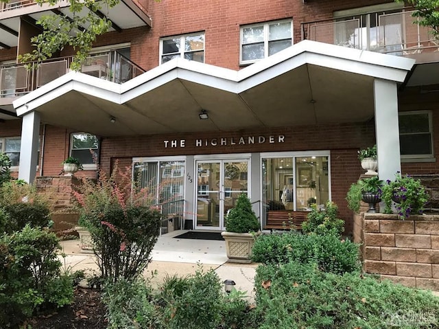 property entrance featuring brick siding and a balcony