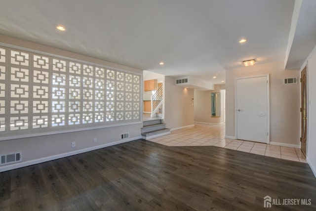 empty room with visible vents, tile patterned flooring, and stairway