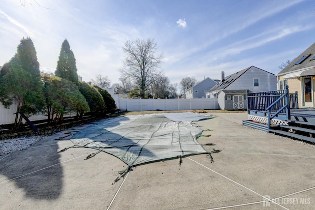 view of pool with an outbuilding, a fenced backyard, a shed, a fenced in pool, and a patio area