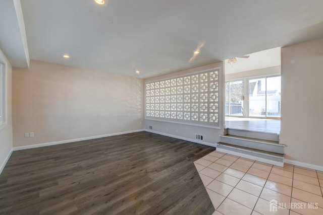 unfurnished room featuring wood finished floors, recessed lighting, baseboards, and visible vents