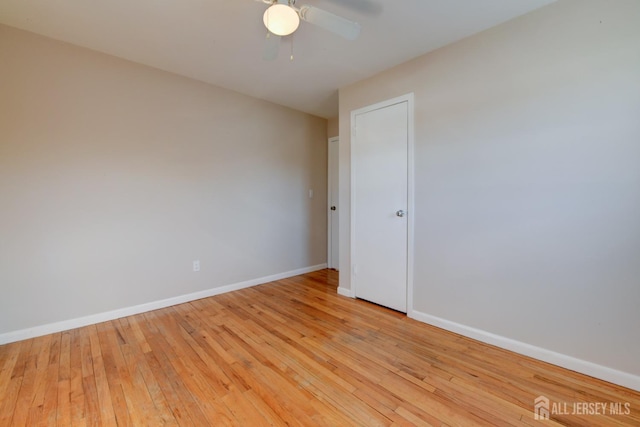 unfurnished room featuring baseboards, light wood-style flooring, and a ceiling fan