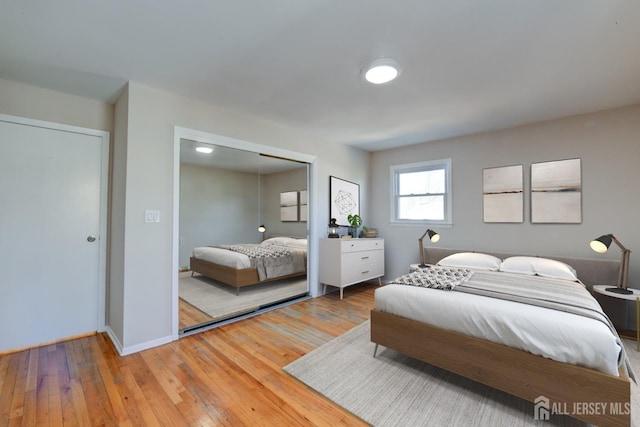 bedroom featuring a closet, baseboards, and hardwood / wood-style floors