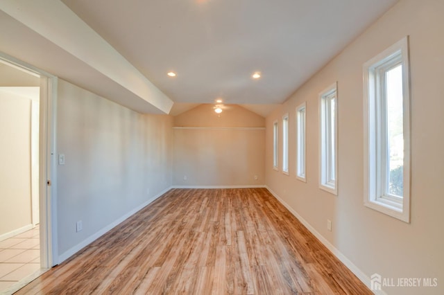 spare room with recessed lighting, baseboards, light wood-style floors, and lofted ceiling