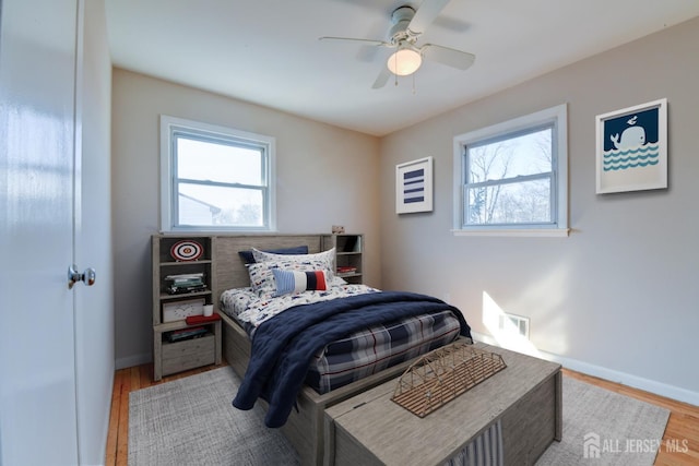 bedroom featuring a ceiling fan, baseboards, and wood finished floors