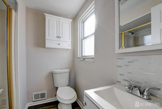 full bath featuring visible vents, toilet, backsplash, a shower, and vanity