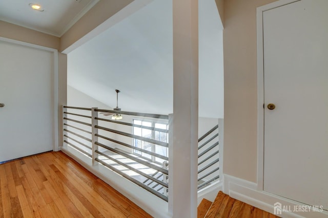 corridor featuring an upstairs landing and light wood-style floors