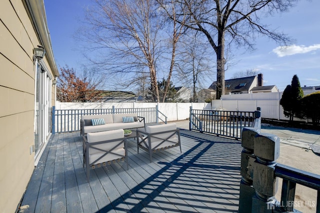 wooden deck with a fenced backyard and an outdoor hangout area