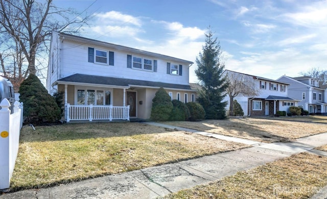 traditional-style house featuring a porch and a front lawn