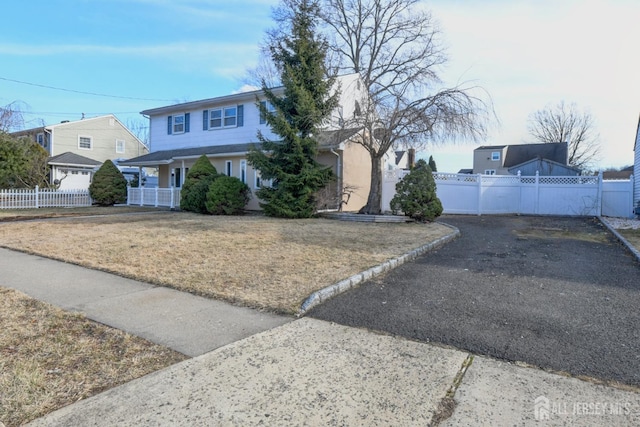 view of front of house with a gate, a front lawn, and fence