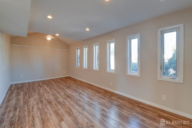 unfurnished room featuring vaulted ceiling, recessed lighting, baseboards, and wood finished floors