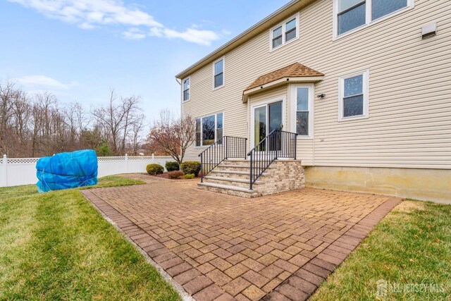 rear view of house featuring a lawn and a patio area