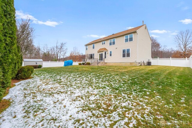 back of house featuring a yard and central AC unit