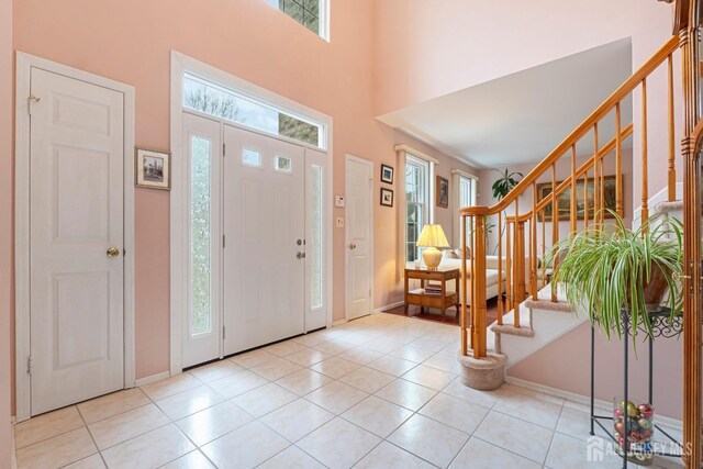 entrance foyer featuring light tile patterned floors and a high ceiling