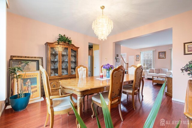 dining area with dark hardwood / wood-style flooring and a chandelier