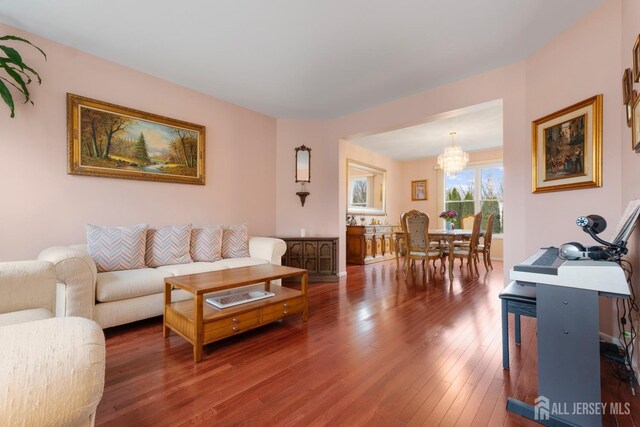 living room featuring dark hardwood / wood-style floors and an inviting chandelier