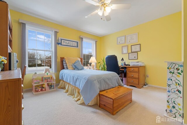 carpeted bedroom with ceiling fan and multiple windows