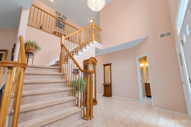 staircase featuring a high ceiling and tile patterned floors