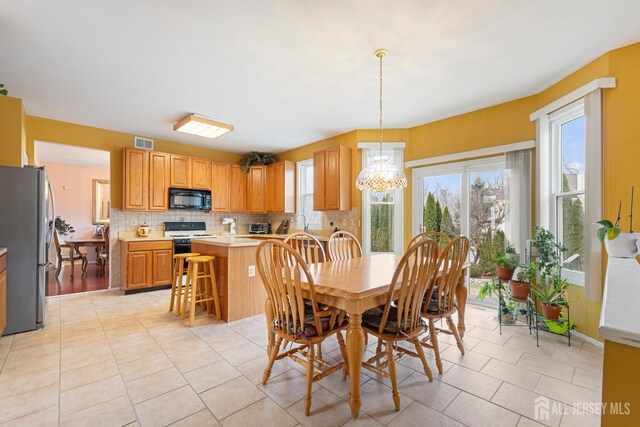 dining room featuring light tile patterned flooring and a chandelier