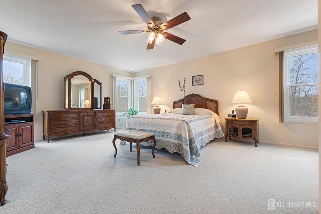 carpeted bedroom with multiple windows and ceiling fan