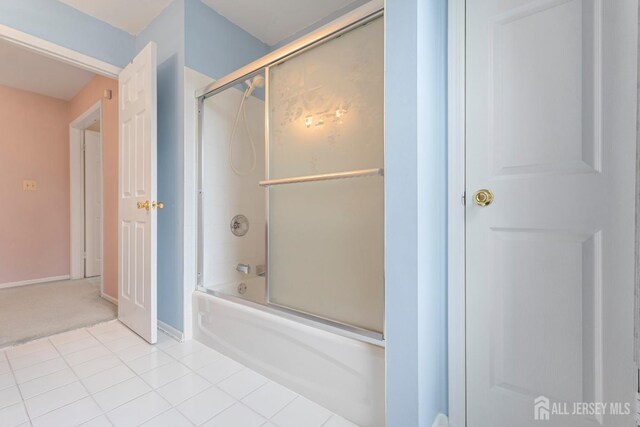 bathroom featuring tile patterned flooring and combined bath / shower with glass door