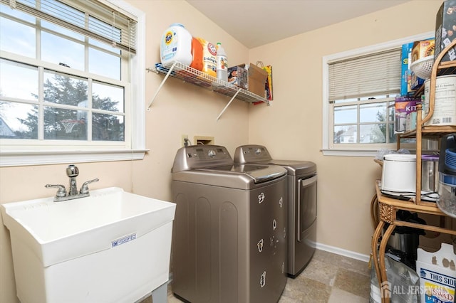 washroom featuring a sink, plenty of natural light, laundry area, and washer and dryer