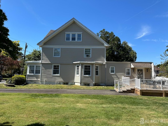 view of front of property featuring a front yard and a deck