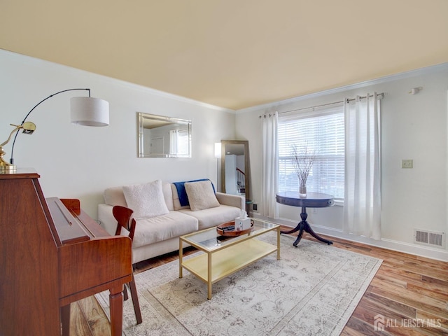 living room with crown molding and light wood-type flooring