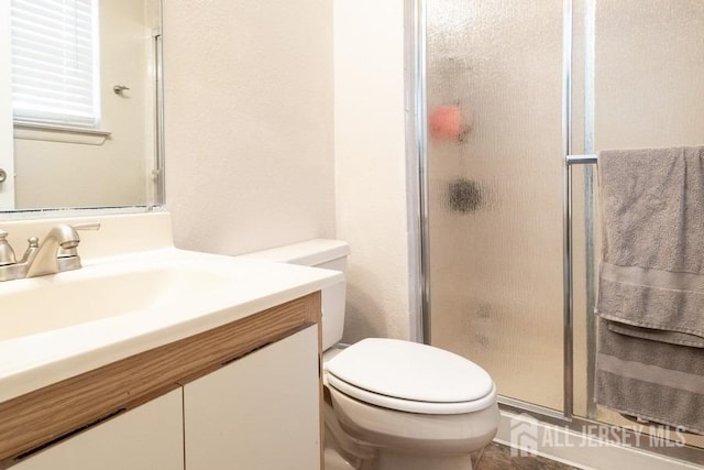 full bathroom with toilet, a shower stall, and vanity