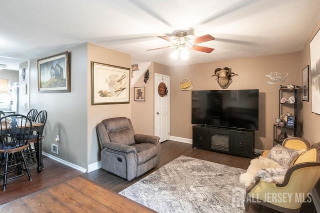 living room with ceiling fan, baseboards, visible vents, and dark wood finished floors