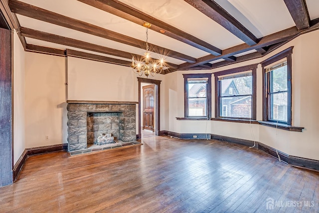 unfurnished living room featuring hardwood / wood-style flooring, a fireplace, baseboards, and an inviting chandelier