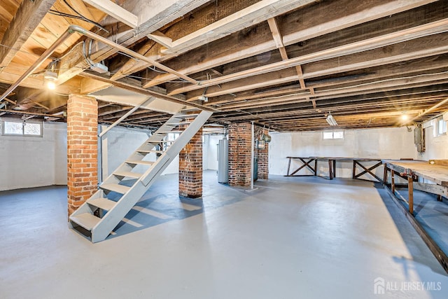 below grade area with water heater, plenty of natural light, and stairs