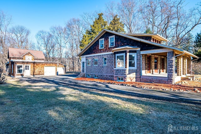 view of side of property with a garage, a yard, and a porch